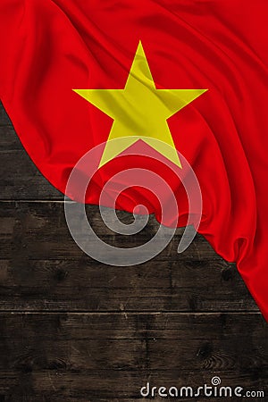 Vertical color national national flag of modern state of Vietnam, beautiful silk, background old wood, concept of tourism, economy Stock Photo