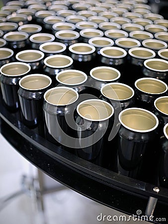 Vertical photo of a raw of beer cans on a platform of a brewery packaging plant Stock Photo