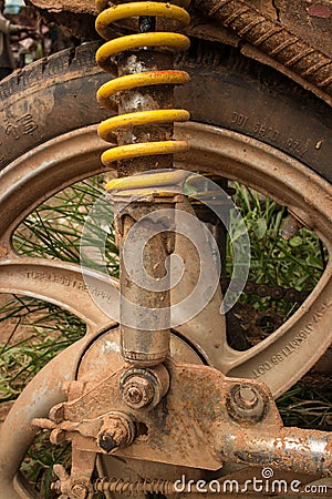 Vertical CU of muddy weathered grungy rear wheel and shock of light motorcycle in Asia Editorial Stock Photo