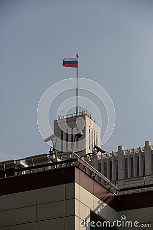 Vertical day shot of three cctv surveillance cameras on the walls of the Parlament, a tower of the white house and the flag of Stock Photo