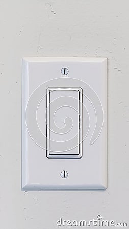 Vertical Electrical rocker light switch with flat broad lever on white interior wall Stock Photo