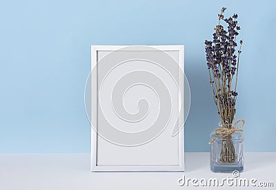 Vertical emply spring white photo frame mockup on a blue background with lavender flowers Stock Photo