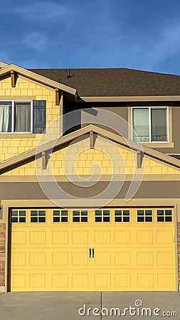 Vertical Exterior of home with view of driveway and garage against blue sky Stock Photo