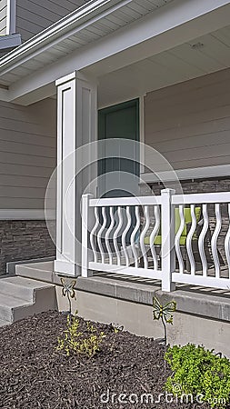 Vertical Facade of a home with view of the porch green front door and white garage door Stock Photo