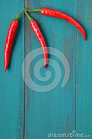 Vertical flat lay view of three hot red chili peppers Stock Photo