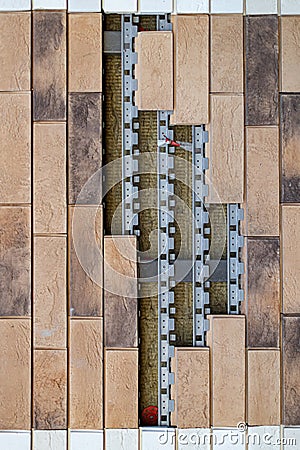 a vertical fragment of a wall that is tiled with a break in it Stock Photo