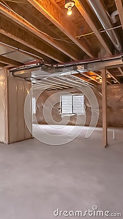 Vertical frame Home under construction with interior framing beams and plastic covered wall Stock Photo