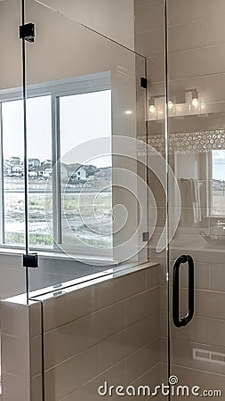 Vertical Frameless walk in shower stall and built in bathtub inside tile wall bathroom Stock Photo