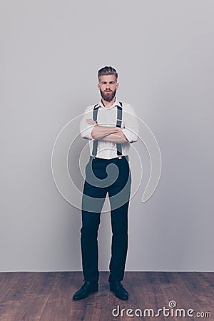 Vertical full-length full-size portrait of brutal handsome strict proud harsh authoritative bossy serious man standing with cross Stock Photo