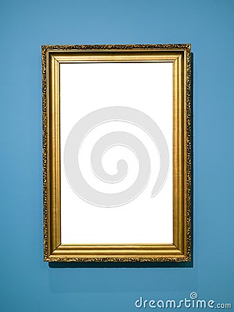Vertical golden wooden picture frame on blue wall Stock Photo