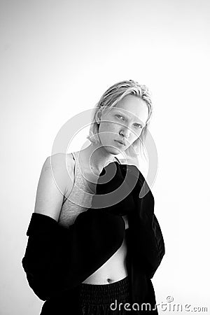Vertical grayscale shot of an attractive Russian female model wearing a suit and posing in a studio Stock Photo