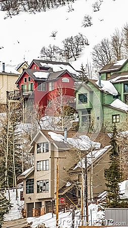 Vertical Homes built on the slope of a mountain blanketed with snow during winter Stock Photo