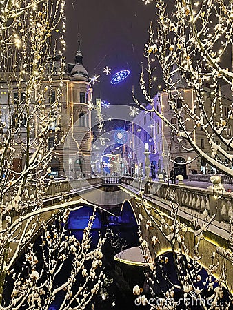 VERTICAL: Idyllic shot of Christmas lights above the three bridges of Ljubljana. Editorial Stock Photo