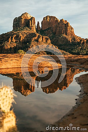 Vertical image of cathedral rock seen from secret slickrock in Sedona Arizona with reflection of geological sandstone rock Stock Photo
