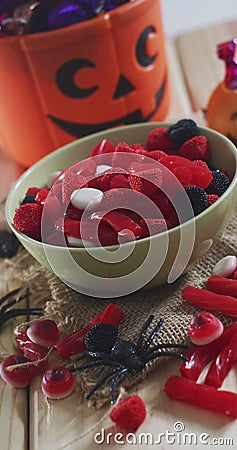 Vertical image of close of candy and halloween pumpkin basket with sweets on rustic background Stock Photo