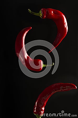 Vertical image.Closeup of flying red chili pepper against blackbackground Stock Photo