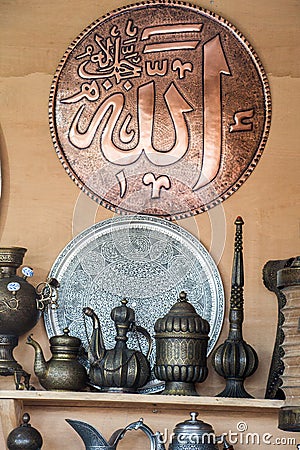 Vertical image of decorative brass jars and plates with the word Allah in Arabic calligraphy Editorial Stock Photo