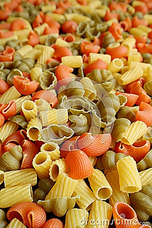 Vertical image of heap of three-color uncooked vegeroni pasta with selective focus Stock Photo