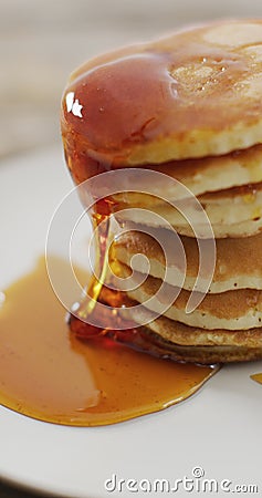 Vertical image of maple syrup pouring onto stack of american style pancakes Stock Photo