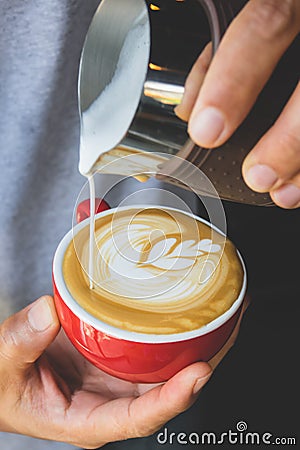 Vertical image of pouring milk to espresso coffee make latte art Stock Photo