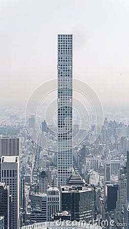 Vertical image of a sleek skinny skyscraper in midtown Manhattan with clear sky Editorial Stock Photo