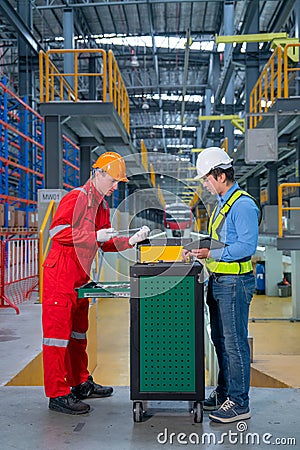 Vertical image of technician and engineer workers discuss about tools and equipment with cabinet in front of railroad tracks of Stock Photo