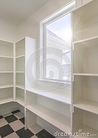 Vertical Interior of an empty kitchen pantry in a house with window Stock Photo