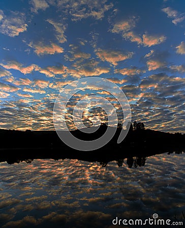 Vertical mesmerizing view of a cloudy sky reflecting in the sea at sunset in Brazil Stock Photo