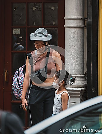 Vertical of a mother smiling and looking at her daughter in Chinatown street in Manhattan, New York Editorial Stock Photo