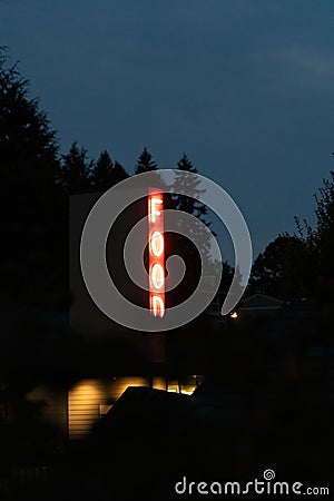 vertical neon sign glowing in the dark late at night Stock Photo