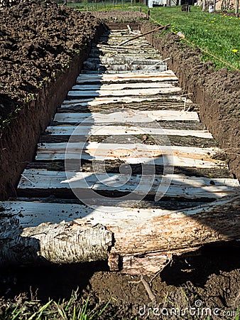 Vertical - Permaculture trench with half long logs of wood Stock Photo