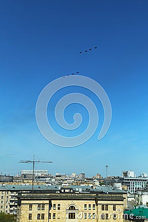 Vertical photo of a group of eight russian military fighter jet planes flying in two rows formation high in blue sky at Vicotry Stock Photo