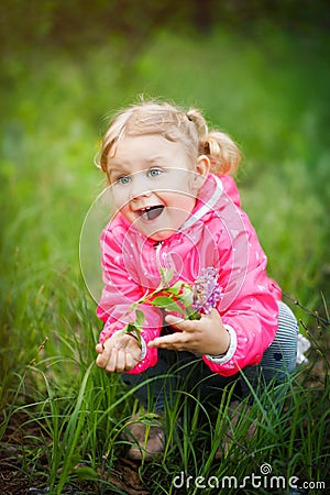 Vertical picture of beautiful little playful 3 years old girl with happy face, pretty eyes, blonde hair, dressed in pink jacket, Stock Photo