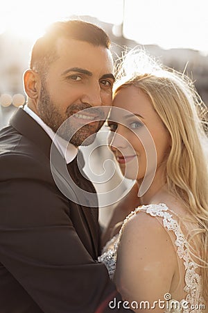 Vertical portrait glad and cheerful romantic married couple, blond woman and black-haired man after wedding, overdressed Stock Photo