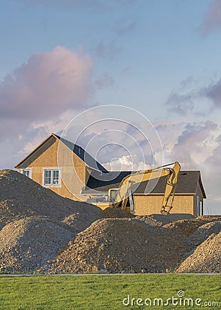 Vertical Puffy clouds at sunset Construction sand piles with two excavators at Utah Stock Photo