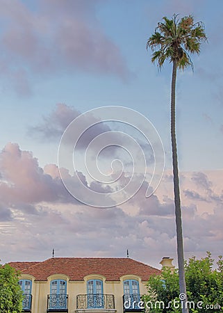Vertical Puffy clouds at sunset Old mediterranean mansion at La Jolla, California with vines on Stock Photo