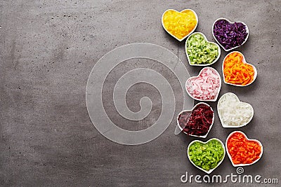 Vertical row of heart-shaped bowls of vegetables Stock Photo