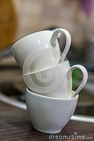 Vertical selective focus shot of a pile of three white tea cups Stock Photo