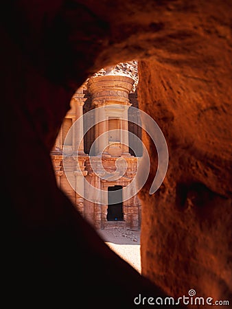 Vertical shot of an ancient archeological temple at historical Petra in Jordan seen through a cave Stock Photo