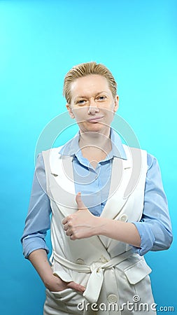 Vertical shot. blonde woman without makeup on a blue background. sign super Stock Photo