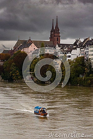 Vertical shot of a Boat riding along the river Rhine with the cathedral, Basel Switzerland Stock Photo