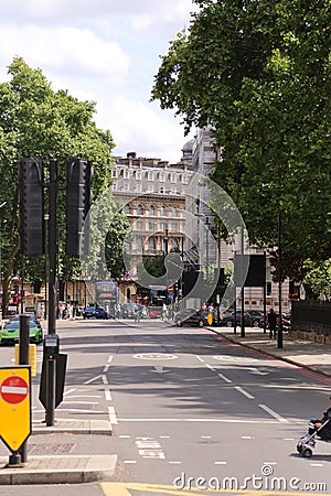 Vertical shot of busy street in London, full of people, trees, street signs, transport, buildings Editorial Stock Photo