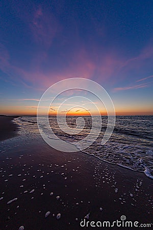 Vertical shot of the calm ocean during the sunset in Vrouwenpolder, Zeeland, Netherlands Stock Photo
