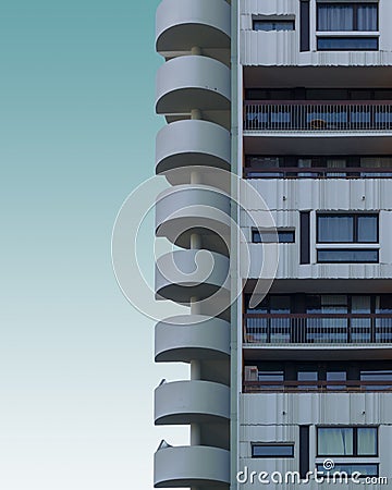 Vertical shot of a cement building with round stairway on a blue background Stock Photo