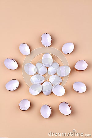 Vertical shot chicken egg shells arranged in a round shape on beige background. Stock Photo