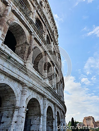 Vertical shot of the Colosseum building under the blue sunny sky, Rome, Italy Stock Photo