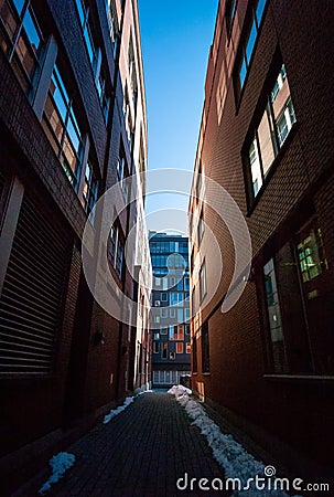 Vertical shot of a dark narrow street in Griffintown in Montreal, Canada Stock Photo