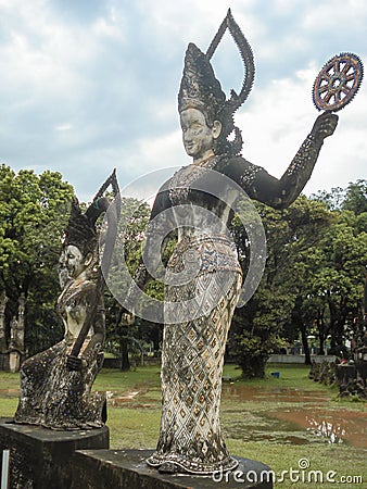 Vertical shot of a divinity sculpture in Xieng Khuan Buddha Park Laos surrounded by vegetation Editorial Stock Photo