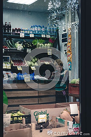 Vertical shot of an elderly female salesperson sitting in a grocery store in Perm, Russia Editorial Stock Photo