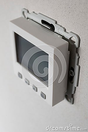 Vertical shot of an electric thermometer hangs on a wall Stock Photo